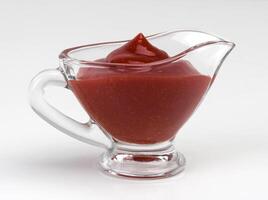 Ketchup in bowl isolated on white background photo