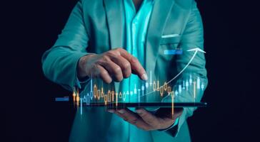 Businessman or trader is touching showing a growing virtual hologram stock on tablet, business planning and strategy, Stock market, Business growth, progress or success concept. Invest in trading. photo