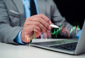 Stock market, Progress or success concept, Business growth, Businessman or trader is showing a growing virtual hologram stock on computer, Planning and strategy, Invest in trading. photo