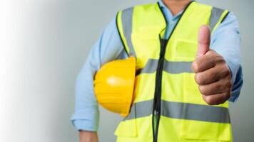 Civil engineer architect standing holding a safety helmet on grey background, Construction site plans to build high-rise buildings, Engineer building concept, Background for construction. photo