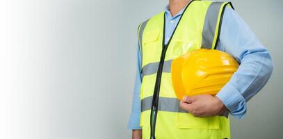 Civil engineer architect standing holding a safety helmet on grey background, Construction site plans to build high-rise buildings, Engineer building concept, Background for construction. photo
