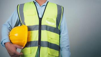 Civil engineer architect standing holding a safety helmet on grey background, Construction site plans to build high-rise buildings, Engineer building concept, Background for construction. photo