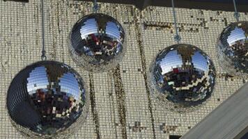 Close-up of hanging disco balls with reflective surfaces capturing vibrant colors and light patterns. Perfect for adding a festive and dynamic element to any party or celebration-themed project video