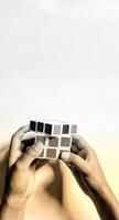CENTRAL JAVA, INDONESIA. April 25th, 2024 - Close up view Man holding rubik's cube, brain training. The Rubik's Cube puzzle on white background morning sunlight concept. photo