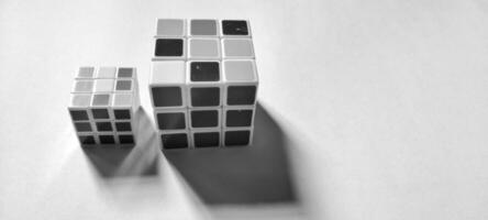 MAGELANG, INDONESIA. April 25th, 2024 - Black and white photo with an abstract photo concept. Close up view of two Rubik's cubes photographed by giving a shadow effect to the object