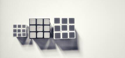 MAGELANG, INDONESIA. April 25th, 2024 - Black and white photo of three Rubik's photographed by giving a shadow effect to the object.