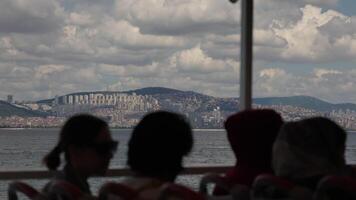 Slow Motion View of Istanbul Cityscape from Ferry with Silhouetted Passengers in Foreground on Cloudy Day video