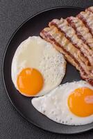 English breakfast with fried eggs, bacon, beans, tomatoes, spices and herbs photo
