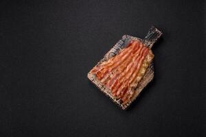 Delicious bacon in the form of slices with salt, spices and herbs photo