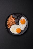 English breakfast with fried eggs, bacon, beans, tomatoes, spices and herbs photo