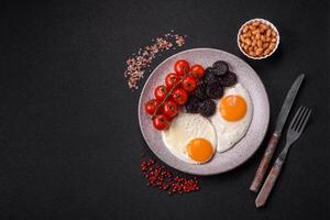 English breakfast with fried eggs, bacon, beans, tomatoes, spices and herbs photo