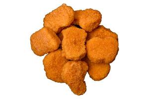 Delicious fresh crispy chicken nuggets on a dark concrete background photo