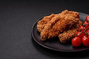 Delicious fresh crispy chicken nuggets on a dark concrete background photo