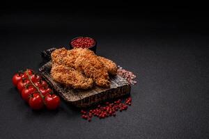 Delicious fresh crispy chicken nuggets on a dark concrete background photo