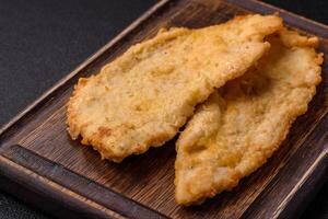 Delicious juicy chicken chops in batter with salt, spices and herbs photo