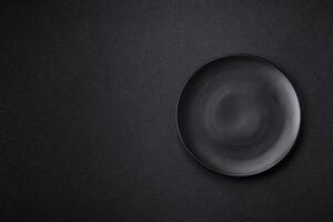 Empty ceramic round plate on dark textured concrete background photo