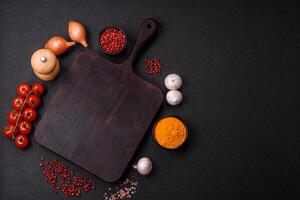 Empty wooden cutting board with spices, salt and herbs photo