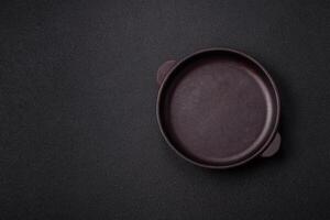 Empty ceramic round plate on dark textured concrete background photo
