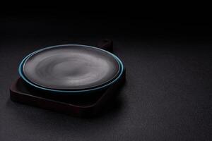 Empty ceramic round plate on dark textured concrete background photo