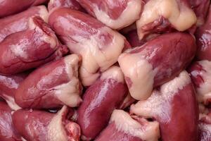 Raw chicken hearts with salt, spices and herbs photo