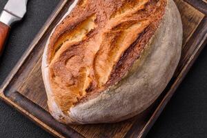 A loaf of brown bread with grains of cereals photo