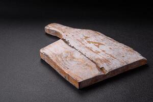 Empty wooden cutting board on dark textured concrete background photo