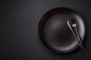 Empty ceramic round plate on dark textured concrete background photo