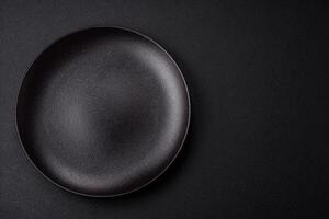 Empty ceramic round plate on dark textured concrete background photo