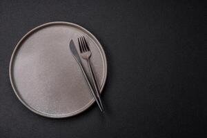 Empty ceramic round plate on dark textured concrete background photo