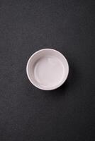 Beautiful empty white ceramic gravy boat on a concrete background photo