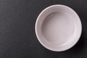 Beautiful empty white ceramic gravy boat on a concrete background photo