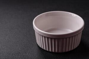 Beautiful empty white ceramic gravy boat on a concrete background photo