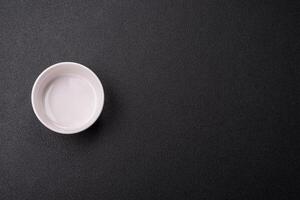 Beautiful empty white ceramic gravy boat on a concrete background photo