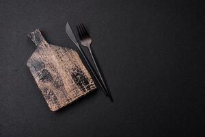 Empty wooden cutting board on dark textured concrete background photo