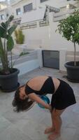 A woman practices rhythmic gymnastics outdoors, demonstrating skill and commitment with a blue ball video