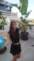 A young woman displaying skill and elegance while practicing rhythmic gymnastics with a blue ball video