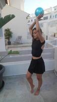 Female dancer practices outdoors with a blue ball, showing skill and determination in dance video