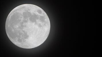 Full moon stars. Glowing yellow huge full moon against starry night sky as seen from earth through clouds. Large full moon moves across the sky, moon makes its way from bottom left frame to top right. video