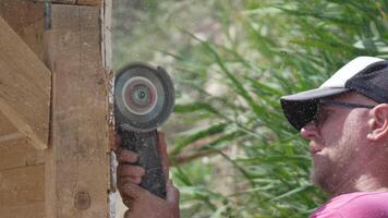 A man is using a power tool to cut wood. Concept of productivity and hard work. Slow motion video