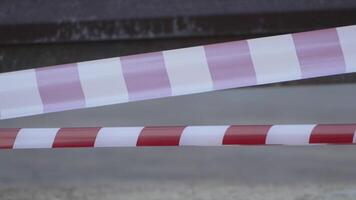 Red and white warning tape swinging in the wind. Protection sign. Don't cross the line. Red White caution tape pole fencing is protects for No entry. Backdrop without people, empty street. video