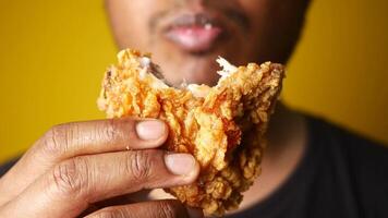 Man enjoying fried chicken, mouth open, savoring every bite with a big smile video