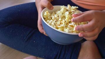 top view of child hand pick popcorn sitting on floor video