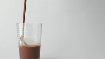 pouring chocolate milk in a glass on white background video