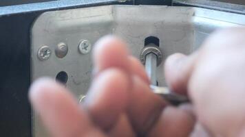 Using a wrench, theyre removing a screw from metal video