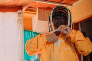 Beekeeper put on a protective beekeeping suit and preparing to enter the apiary photo