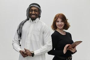 Arabic entrepreneur and a businesswoman, exuding confidence and unity, pose together against a clean white backdrop, symbolizing a dynamic partnership characterized by ambition, innovation, and photo