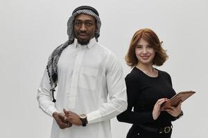 Arabic entrepreneur and a businesswoman, exuding confidence and unity, pose together against a clean white backdrop, symbolizing a dynamic partnership characterized by ambition, innovation, and photo