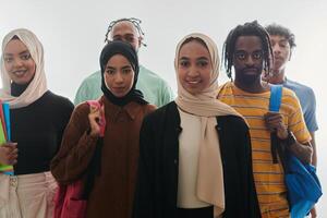 In a vibrant display of educational diversity, a group of students strikes a pose against a clean white background, holding backpacks, laptops, and tablets, symbolizing a blend of modern technology photo