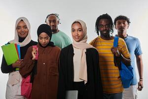 In a vibrant display of educational diversity, a group of students strikes a pose against a clean white background, holding backpacks, laptops, and tablets, symbolizing a blend of modern technology photo