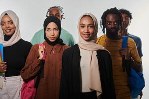 In a vibrant display of educational diversity, a group of students strikes a pose against a clean white background, holding backpacks, laptops, and tablets, symbolizing a blend of modern technology photo